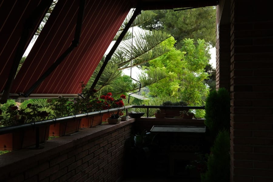 A shaded balcony with potted plants